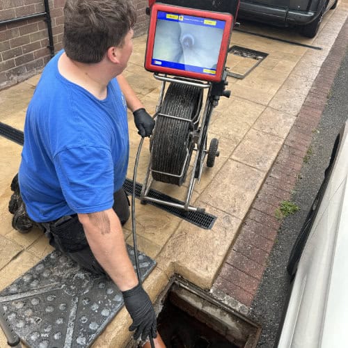 A professional drain cleaner working on a stinky drain