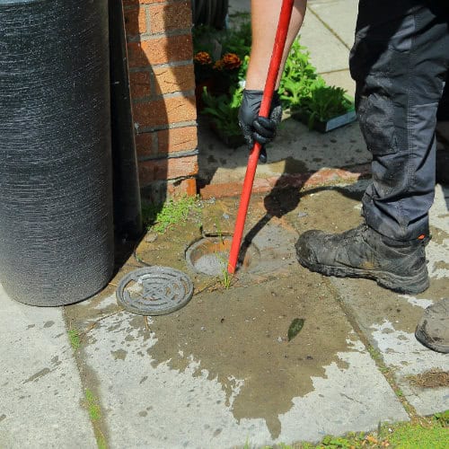 A blocked drain clearance being taken by an engineer