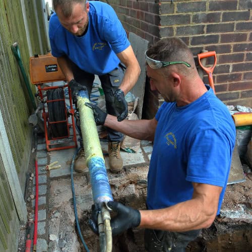 Two drain specialists getting ready to install a drain liner