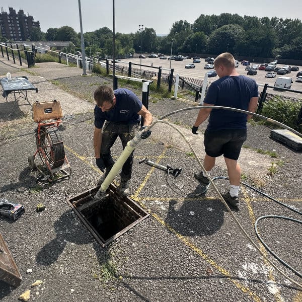 Two drain repair specialists undertaking a drain lining project