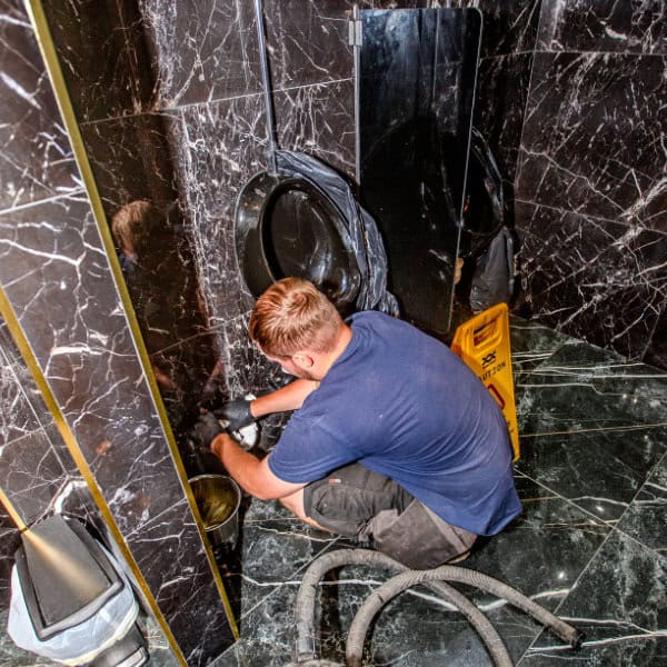 A drainage engineer working to unblock a blocked toilet at a bar in Cheshire